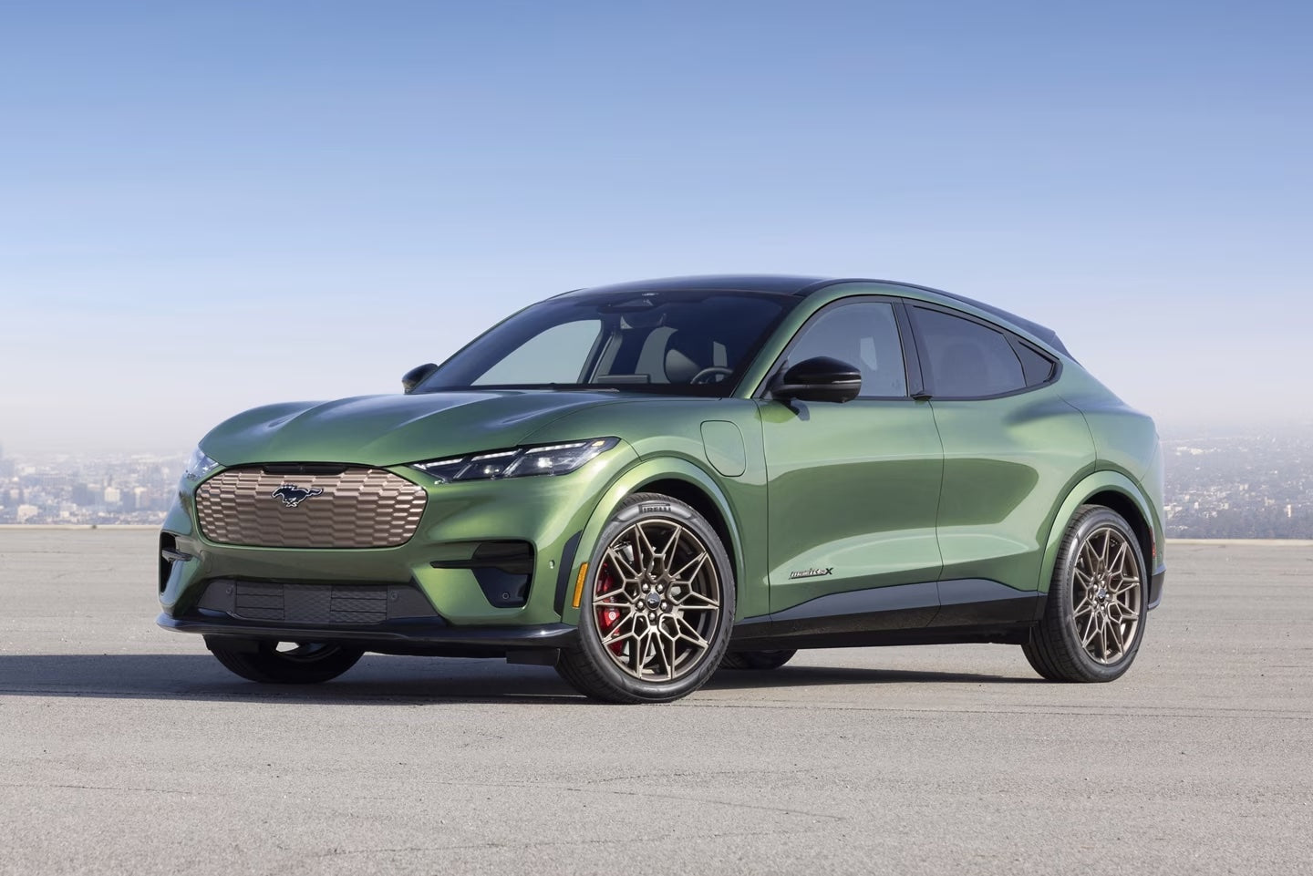 Green Ford Mustang Mach-E parked on an open road.