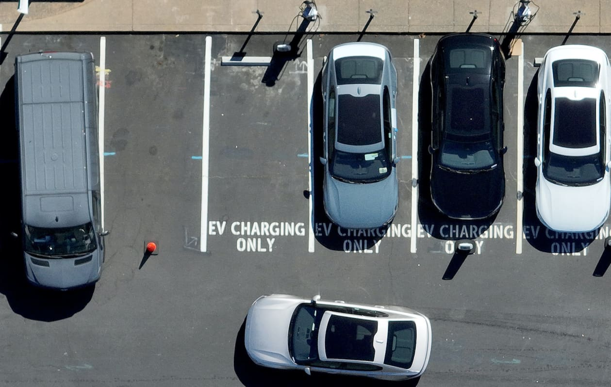 Aerial view of EV charging stations with cars parked.