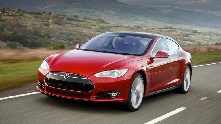 Red Model S driving on the road.