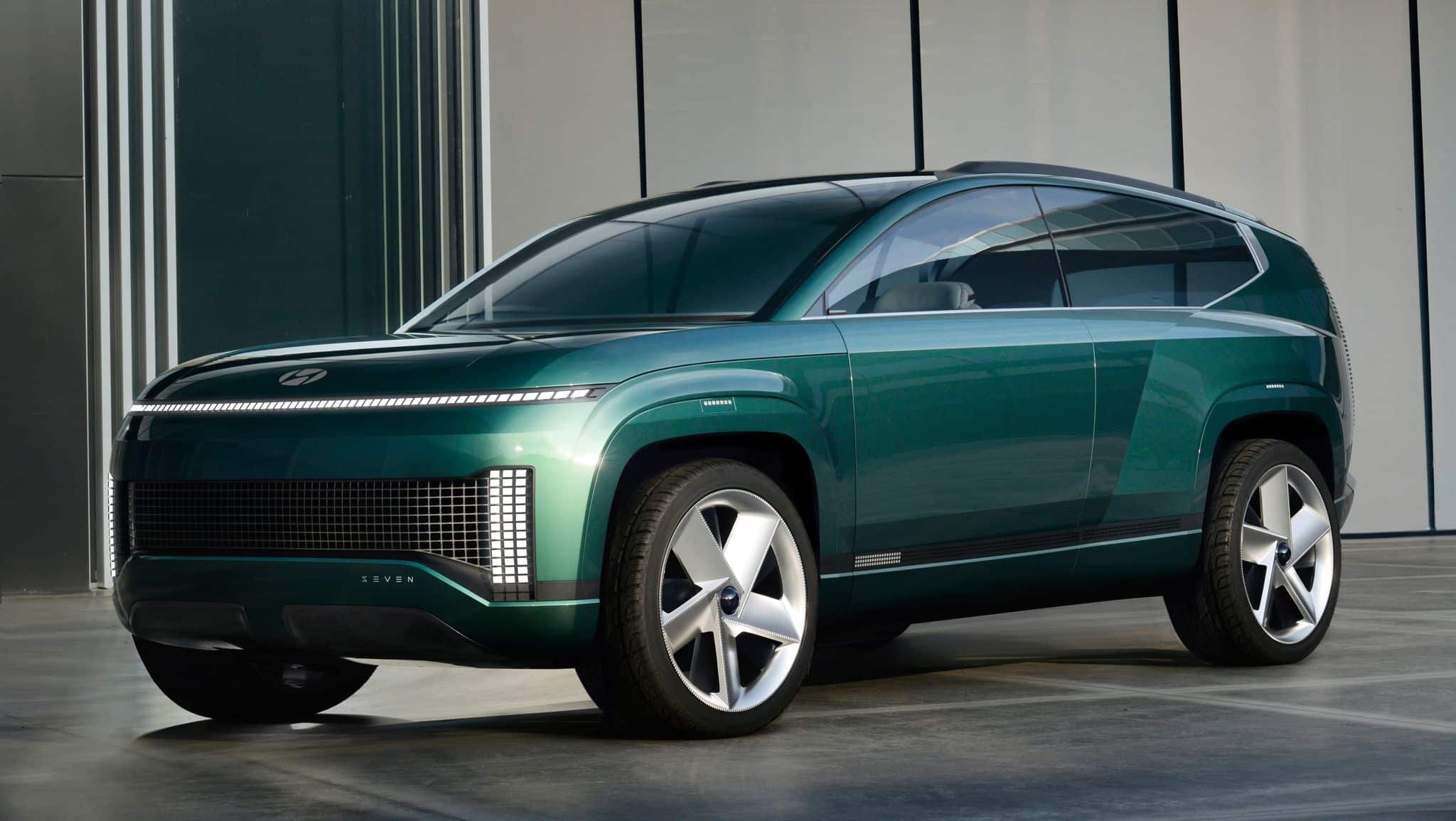 Green Hyundai SUV showcased in front of a modern building.