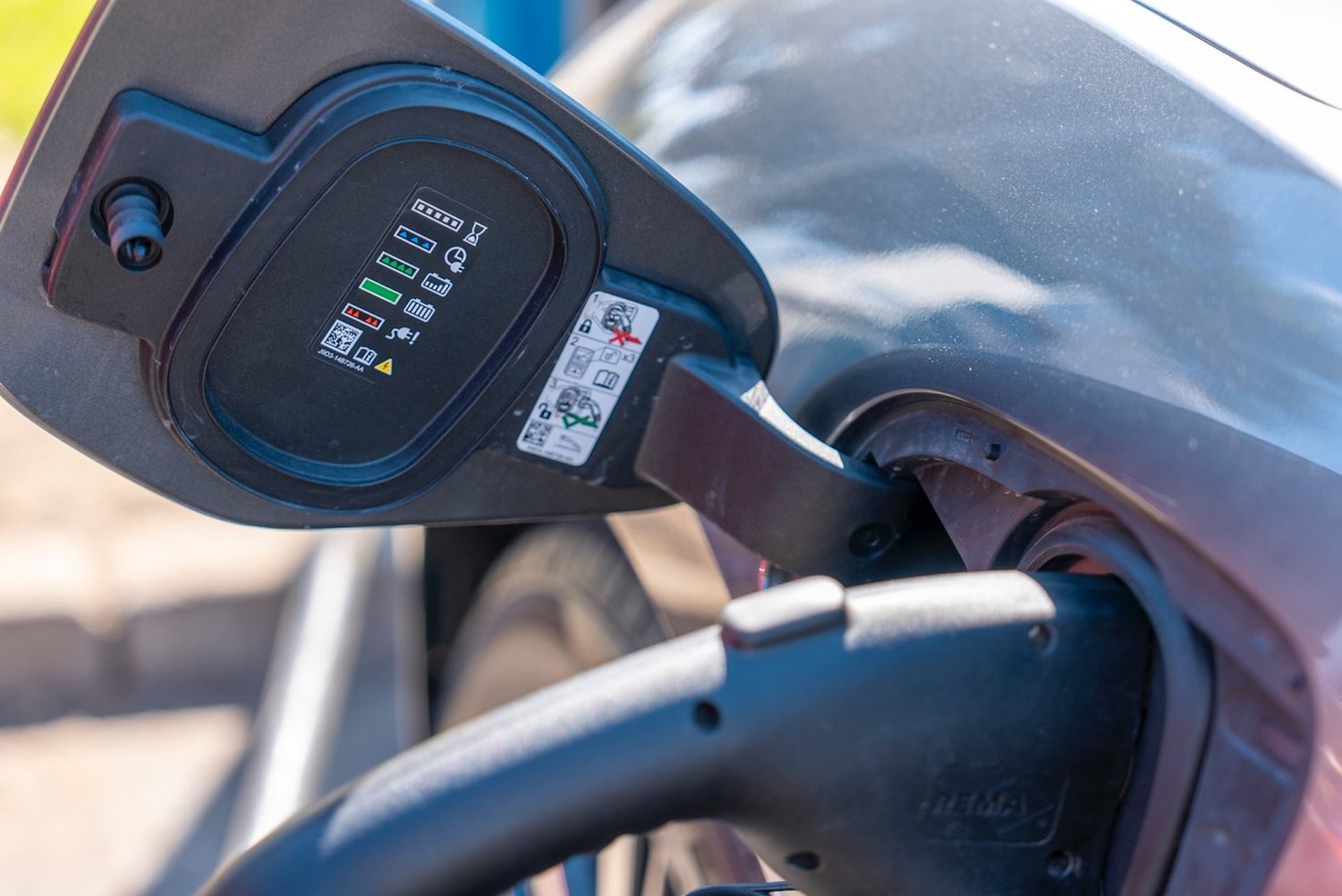 An EV is charging by an EV charger.