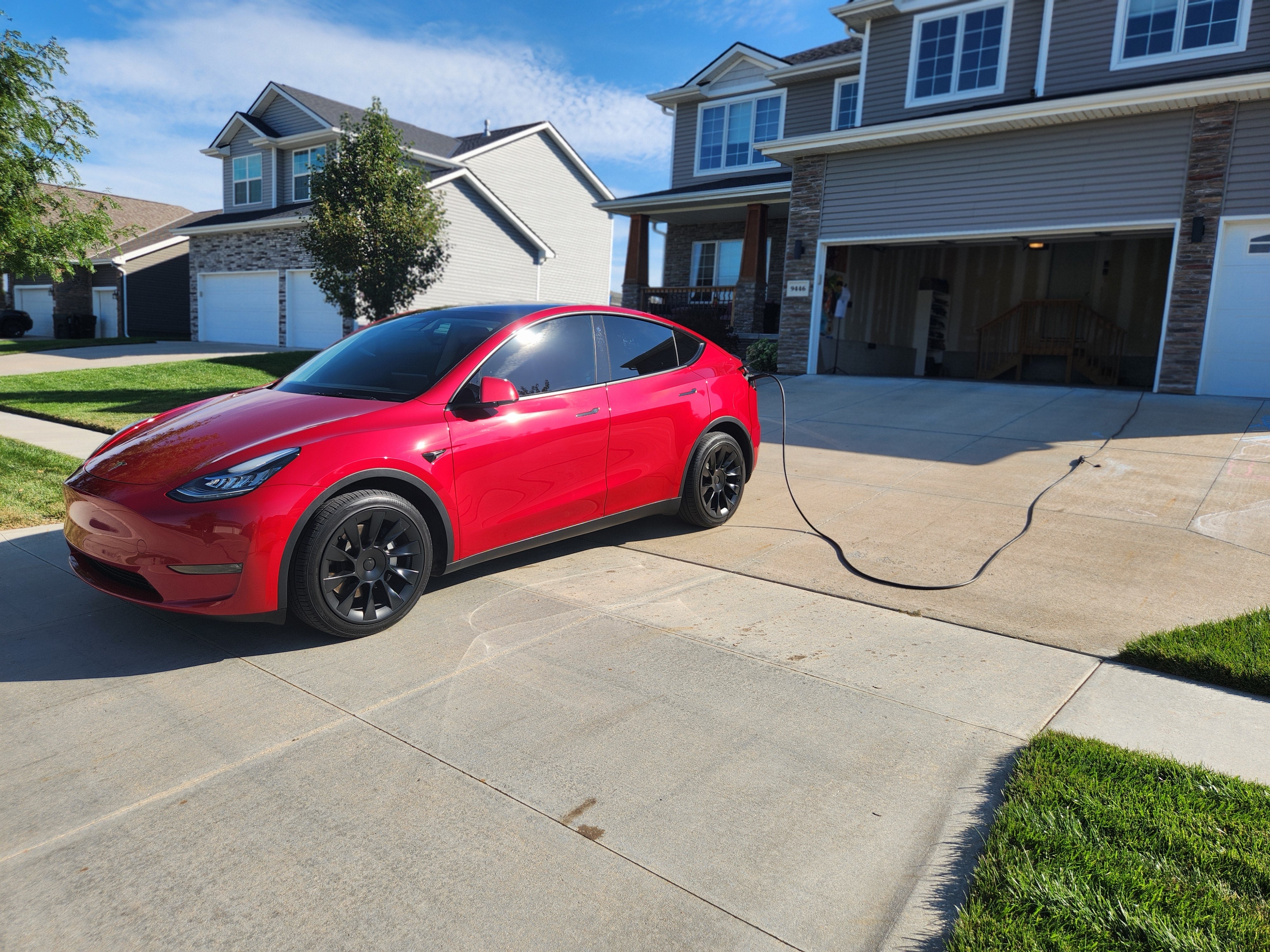 A Tesla owner is using the EVDANCE Tesla Extension Cord to charge his Tesla car parked outside his garage by connecting it to the EVDANCE Tesla Charger wired from an outlet inside his detached apartment!