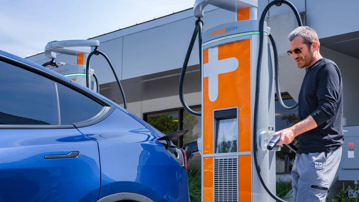 A man using Chargepoint DC fast charger to charge his Tesla vehicle.
