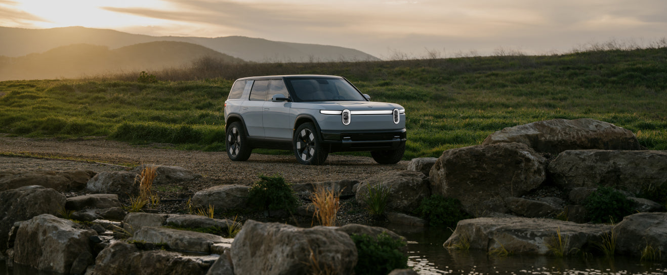 A Rivian R2 driving on the road.