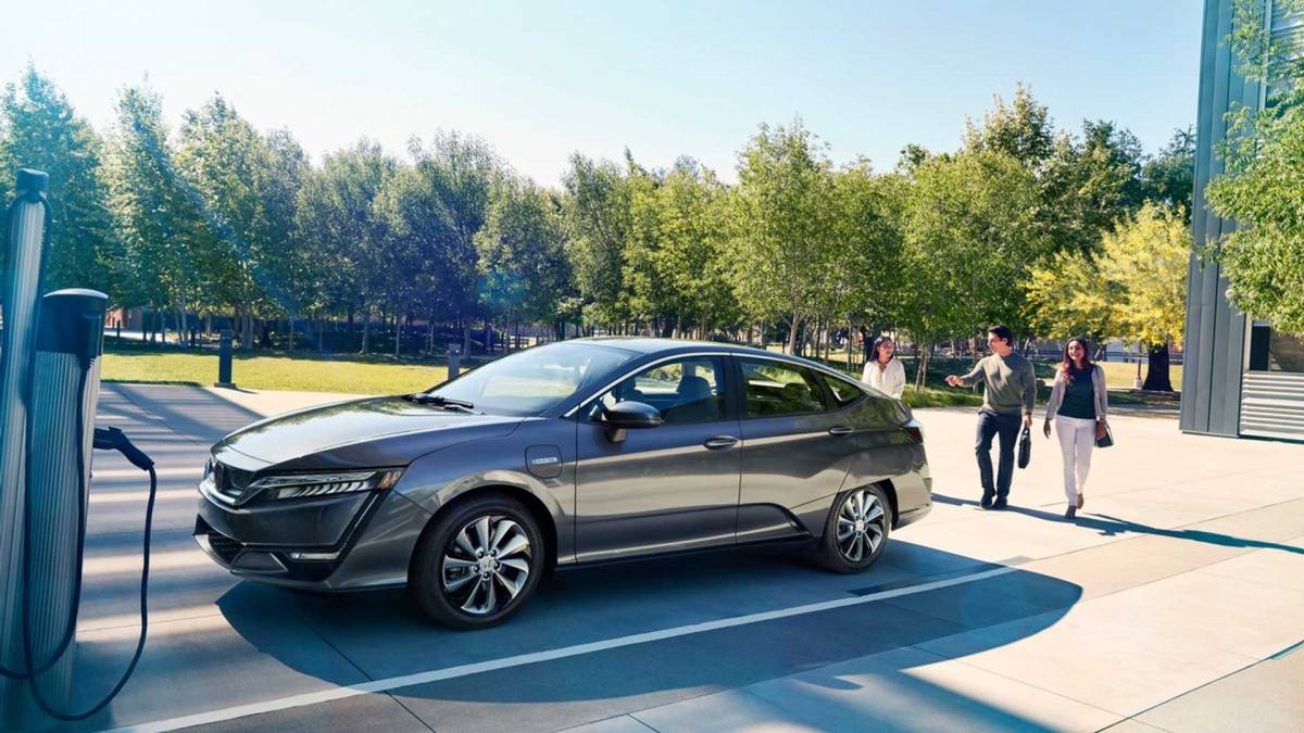 A brand new EV is charging by a public charger.